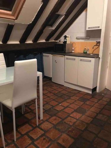 une cuisine avec une table et une chaise blanches dans l'établissement Rue du poirier, à Orléans