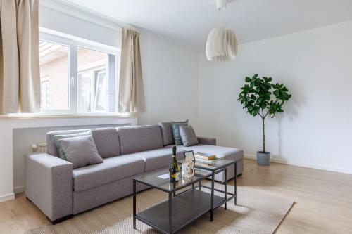 ein Wohnzimmer mit einem Sofa und einem Tisch in der Unterkunft Sweet Inn - Michel Ange in Brüssel