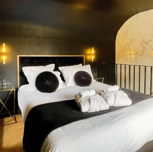 una gran cama blanca con almohadas. en La Croisée des Sens, en Croisy-sur-Eure