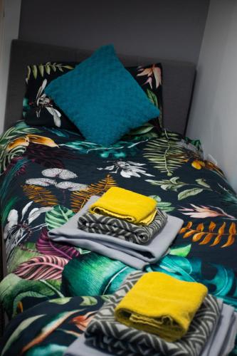 a bed with a pile of towels on it at Cosy Modern Flat (NEC/BHX Stays) in Marston Green