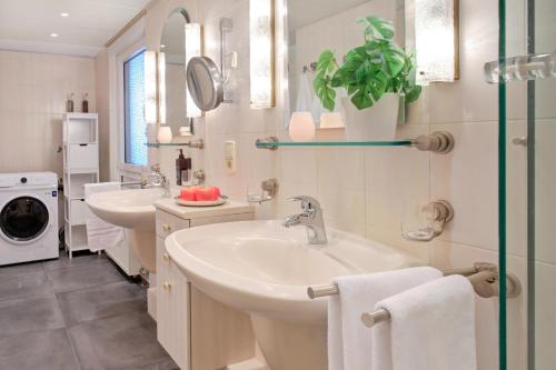 a bathroom with two sinks and a washing machine at Das Penthouse - Jacuzzi - BBQ - Dachterrasse in Karlsruhe