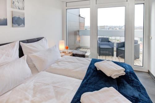 a bedroom with a white bed and a balcony at Das Penthouse - Jacuzzi - BBQ - Dachterrasse in Karlsruhe