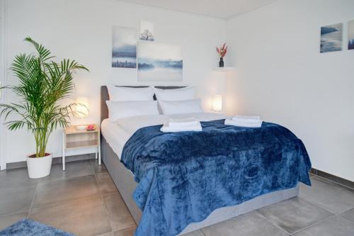 a bedroom with a large bed with a blue blanket at Das Penthouse - Jacuzzi - BBQ - Dachterrasse in Karlsruhe