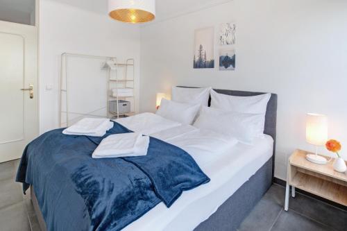 a large white bed with two towels on top of it at Das Penthouse - Jacuzzi - BBQ - Dachterrasse in Karlsruhe