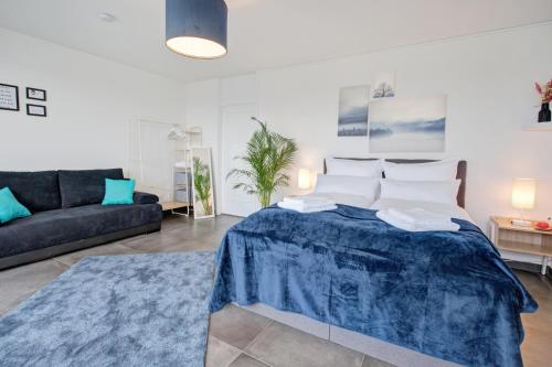 a living room with a bed and a couch at Das Penthouse - Jacuzzi - BBQ - Dachterrasse in Karlsruhe