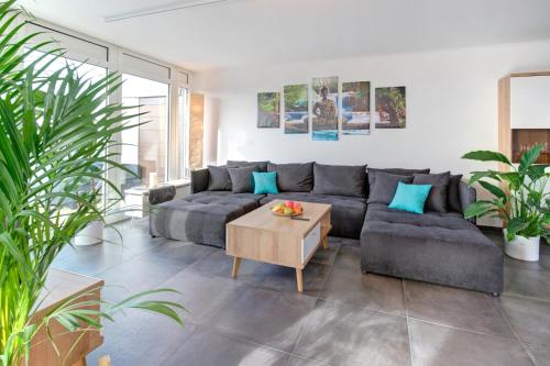 a living room with a couch and a coffee table at Das Penthouse - Jacuzzi - BBQ - Dachterrasse in Karlsruhe