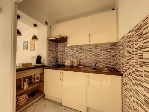 - une cuisine avec un évier et un mur en briques dans l'établissement Cosy - Vue imprenable sur le lac, à Tresserves