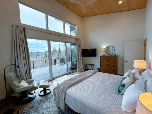 a bedroom with a large bed and a large window at 1A Maple Lodge Stunning luxury Scandinavian style home with great views in Bethlehem