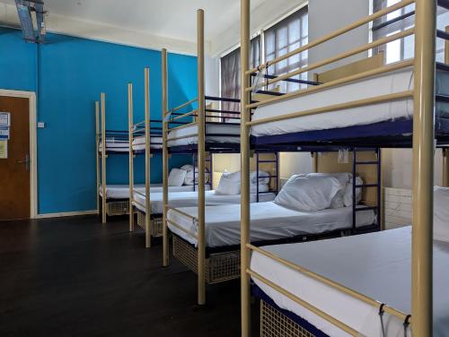 four bunk beds in a room with blue walls at Rock n Bowl in Bristol