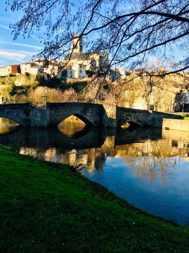 a bridge over a river with a building in the background at Moon River Bellac Chambre d'hotes in Bellac