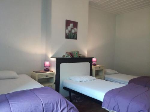 a room with two beds and two tables with candles at Gite au sein du Parc des Volcans d'Auvergne, tous commerces à pied in Neussargues-Moissac