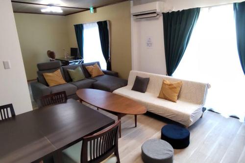 - un salon avec un canapé et une table dans l'établissement Villa Hikone Castle, à Hikone