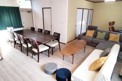 a living room with a table and a couch at Villa Hikone Castle ヴィラ彦根キャッスル 彦根城9分 10人泊 キャッスルロード4分 ひこにゃん4分 駐車3台 ビワイチ in Hikone