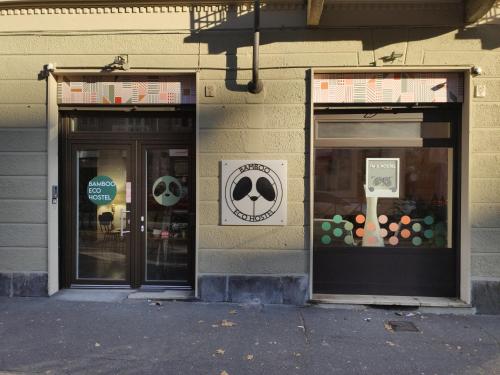 two windows of a store with signs on them at Bamboo Eco Hostel in Turin