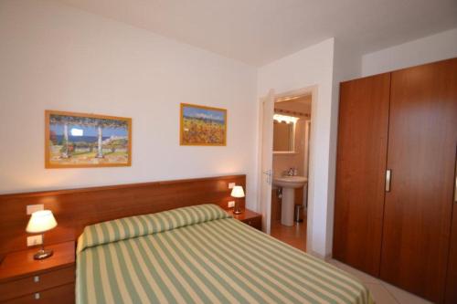 um quarto de hotel com uma cama e um lavatório em Coastal escape modern flat with Wi-Fi em Bibione