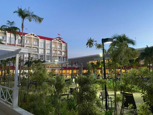 a hotel with a courtyard with palm trees and a building at 1 suite no Aguas de São Pedro Thermas Resort in São Pedro