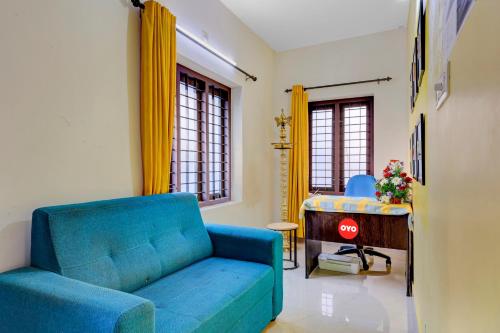 a living room with a blue couch and a table at OYO Hi 5 Apartments in Cochin