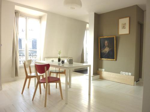 une salle à manger avec une table et des chaises dans l'établissement 3 rooms apartment business rooftop view to Montmartre, à Paris