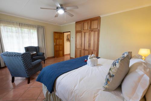 a bedroom with a bed with a teddy bear on it at Modjadji Estate Lodge & Spa in Grietjie Nature Reserve