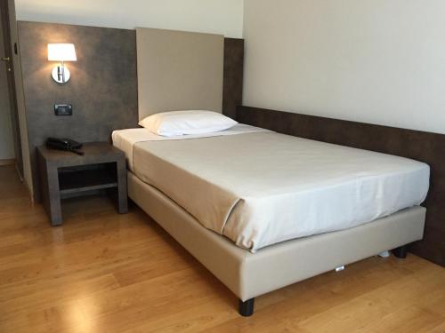 a bedroom with a bed and a nightstand with a white bed sidx sidx sidx at Jet Hotel in Caselle Torinese