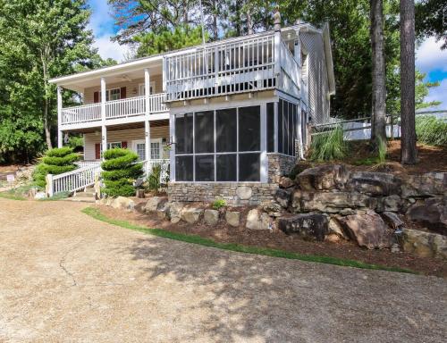 a large white house with a stone wall at House #14 Pelican Sunrise (no pets) Lake View in Centre