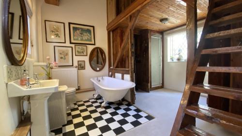 uma casa de banho com uma banheira branca, um lavatório e um WC. em The Clock House em Ventnor