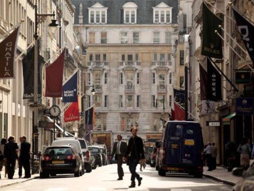 倫敦的住宿－Bond Street Mayfair Penthouse，一条繁忙的城市街道,有汽车和人沿着街道走