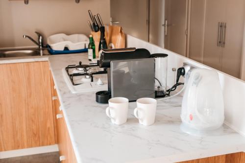 una barra de cocina con tres tazas de café. en Pivoine Camping Belle-Vue 2000, en Berdorf