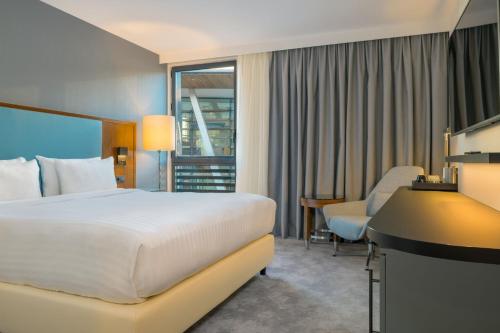 Pokój hotelowy z łóżkiem i biurkiem w obiekcie Courtyard by Marriott Paris Arcueil w mieście Arcueil