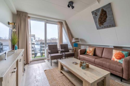 a living room with a couch and a table at Anna 224 in De Koog