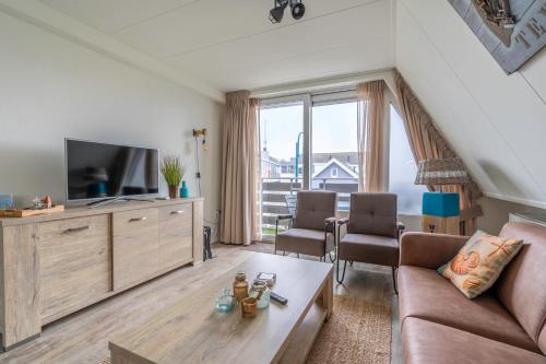 a living room with a couch and a tv at Anna 224 in De Koog