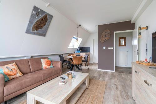 a living room with a couch and a table at Anna 224 in De Koog