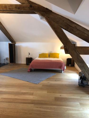 a bedroom with a bed in a attic at LE MOULIN DE LONGCHAMP - Maison d'Hôtes in Lent