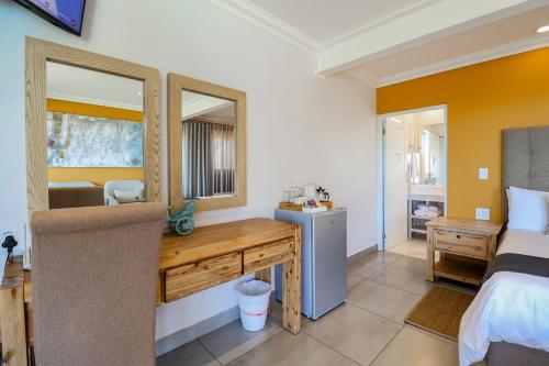 a bedroom with a desk and a bed at Belle Vue Ridge BnB, in Plettenberg Bay