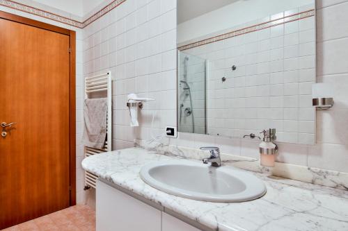 a white bathroom with a sink and a mirror at Residence Montegrappa in Sandrigo