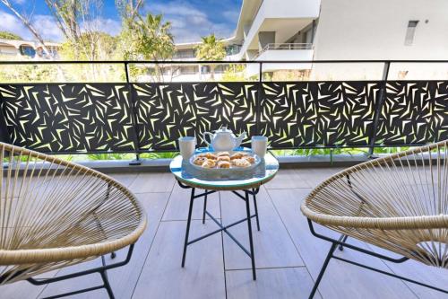 une table avec un bol de nourriture sur un balcon dans l'établissement 06AH - Superb waterfront T2 - swimming pool, à Villeneuve-Loubet