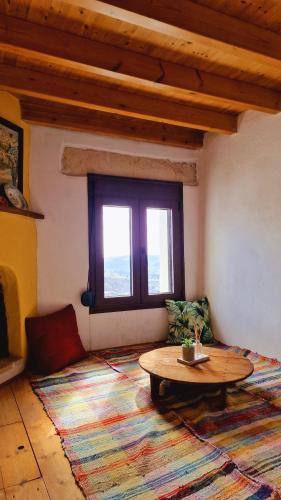 a living room with a coffee table and a rug at Yiannis Village house in Asklipiḯon