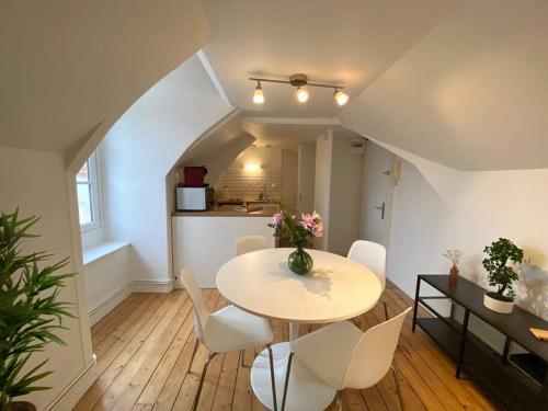 une salle à manger avec une table et des chaises blanches dans l'établissement Le Thabor - T3 proche Centre Rennes, à Rennes