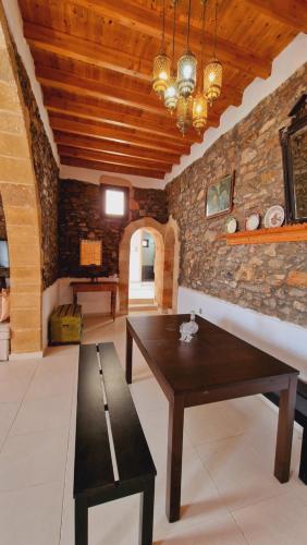 a living room with a wooden table and a bench at Yiannis Village house in Asklipiḯon