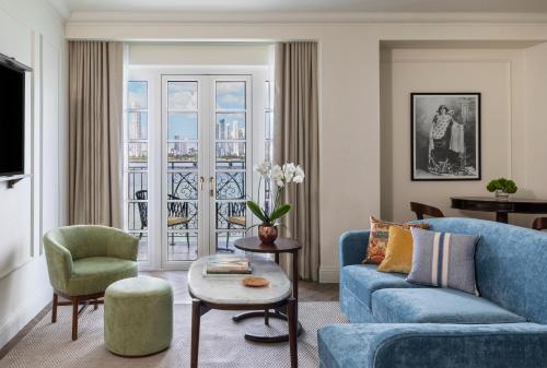 a living room with a blue couch and a chair at Sofitel Legend Casco Viejo, Panama City in Panama City