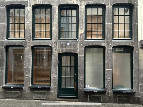 a building with eight windows and a green door at Open Space Loft in Cologne