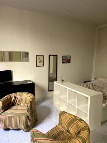 un soggiorno con sedia e letto di Piccinardihouse - appartamento Crema centro storico a Crema