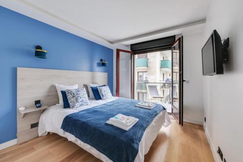 une chambre avec un grand lit avec un mur bleu dans l'établissement 181 One Suite - Superb apartment in Paris., à Paris