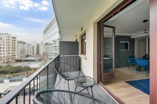un balcon avec deux chaises et une table sur un immeuble dans l'établissement 181 One Suite - Superb apartment in Paris., à Paris