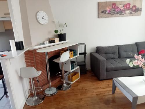 ein Wohnzimmer mit einem Sofa und einem Tisch in der Unterkunft Bel appartement lumineux avec terrasse proche centre ville et plages in Douarnenez