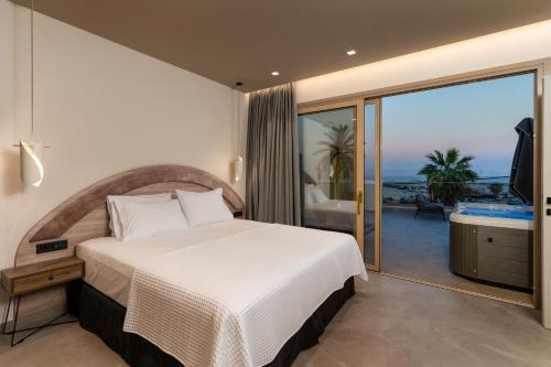 a bedroom with a bed and a view of the ocean at Cove Luxury Suites in Agia Galini