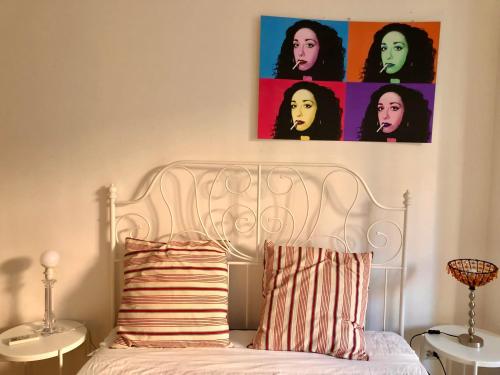 a bedroom with a white bed and a painting on the wall at TERRAZZA SUL GIARDINO - Vaticano e Stadio Olimpico in Rome