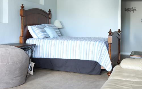 een slaapkamer met een bed met blauwe en witte strepen bij House# 34 Whale Watchers Folly 4BR (pet friendly) in Centre