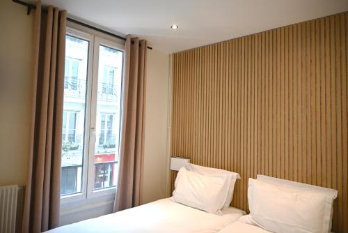 une chambre d'hôtel avec un lit et une fenêtre dans l'établissement Pavillon de Montmartre, à Paris