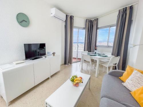 a living room with a couch and a tv and a table at Club Maritimo at Ronda III in Fuengirola